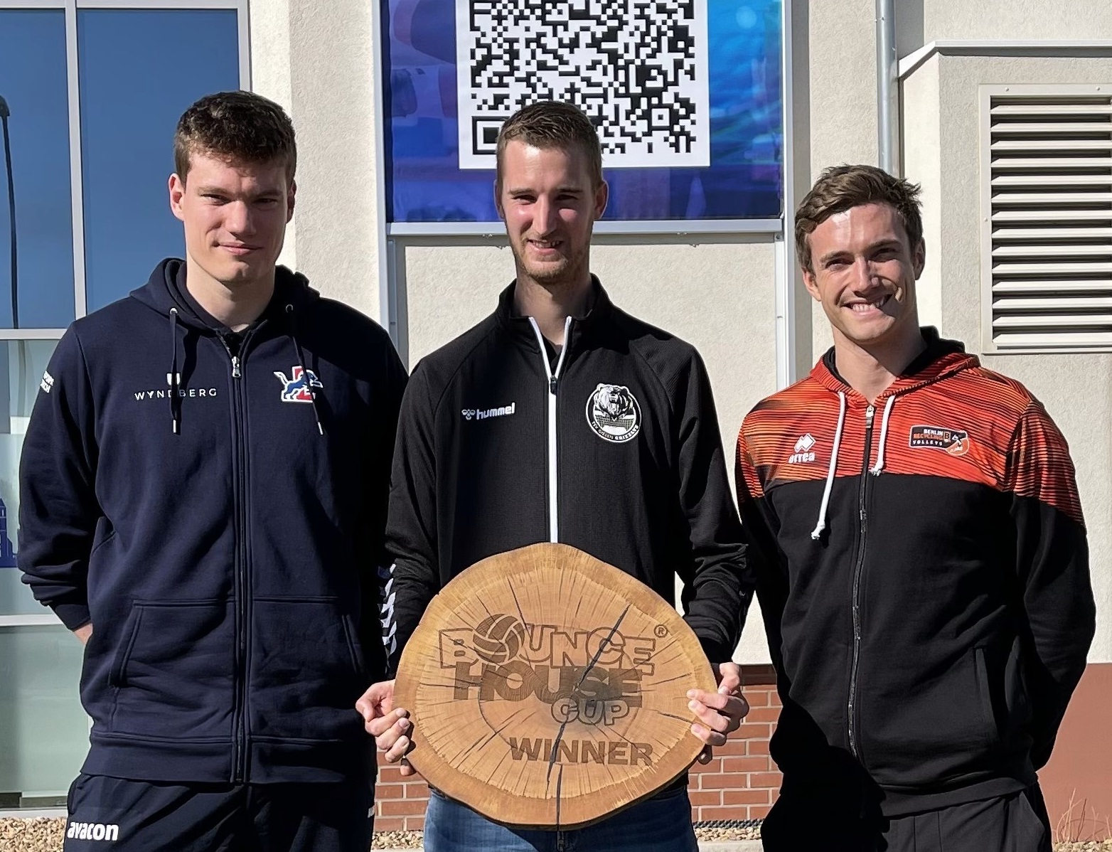 Ein aktueller und zwei ehemalige LüneHünen präsentieren nach einem Pressetermin die Trophäe, die es beim Bounce House Cup außer Prestige zu gewinnen gibt (v.l.): Lukas Maase, der mit Friedrichshafen den DVV-Pokal gewann, Noah Baxpöhler vom Veranstalter Giesen und Cody Kessel vom amtierenden Meister Berlin.